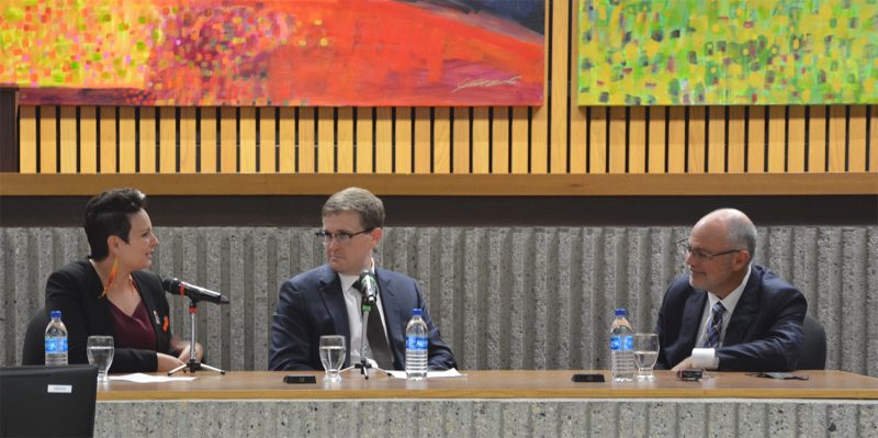 Photo of law student Melinda Much asking Supreme Court of Canada Justice Russell Brown a question while Assistant Professor Gerard Kennedy looks on in Robson Hall's Moot Courtroom.