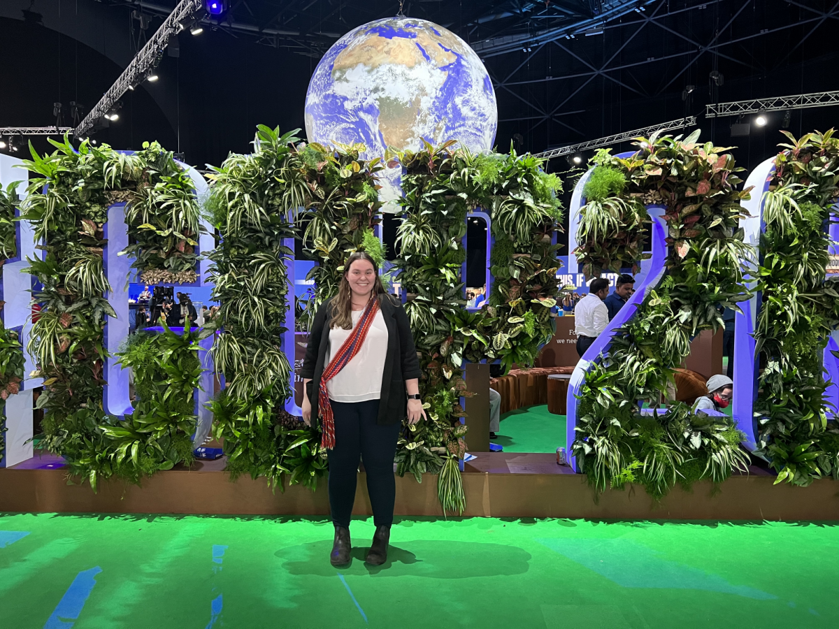 Fiona Lebar stands in front of the COP26 sign, made of plants
