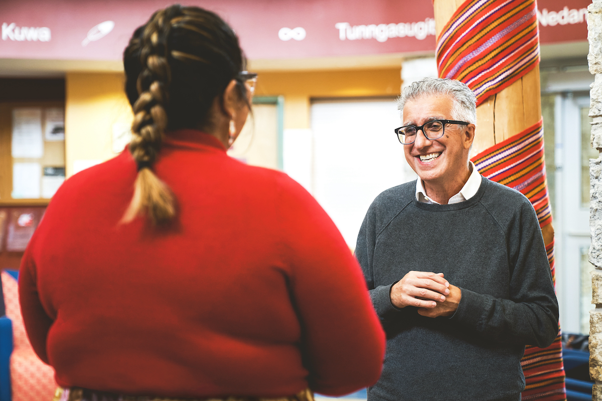 President Michael Benarroch speaks with a student at Migizii Agamik.