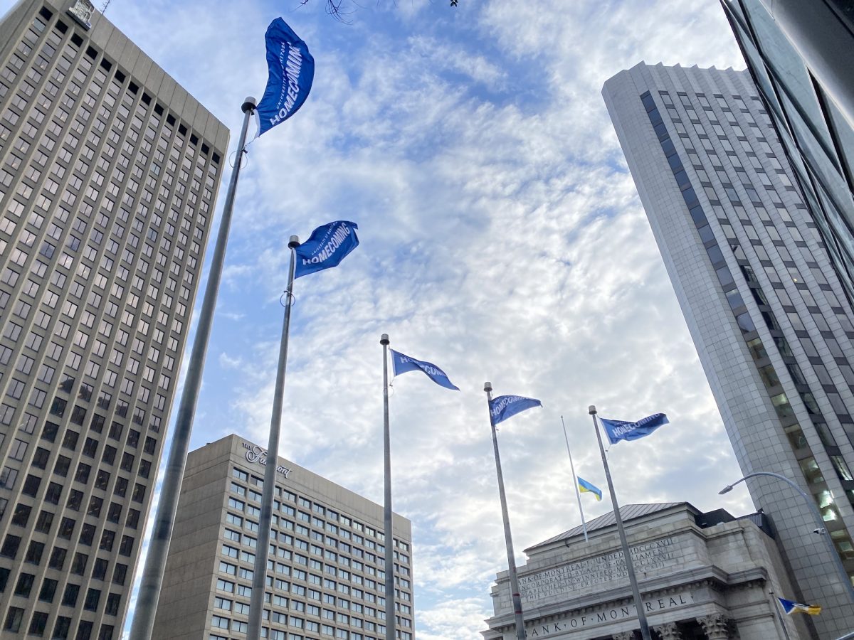 UM Homecoming flags flying at Portage and Main intersection in Winnipeg.