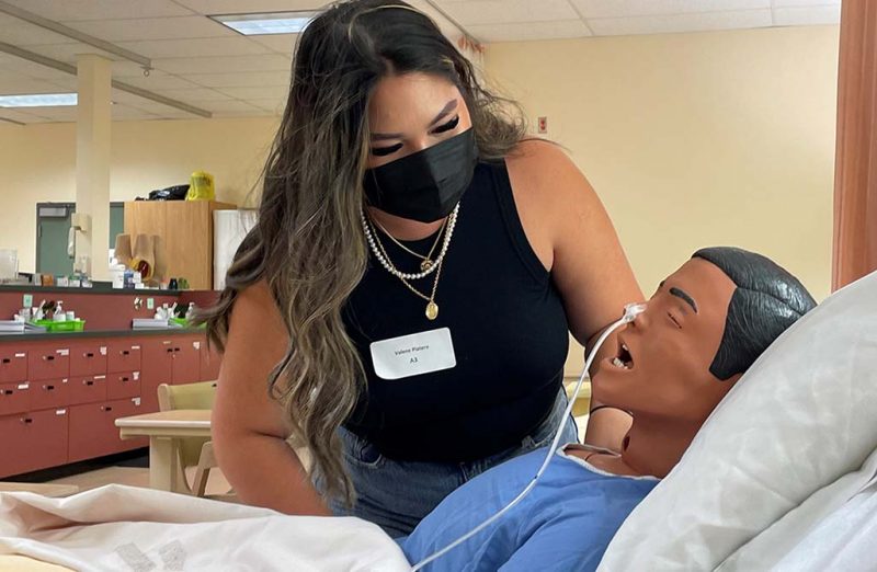 A female nursing student examines a lifelike manikin at the college of nursing's simulation lab.