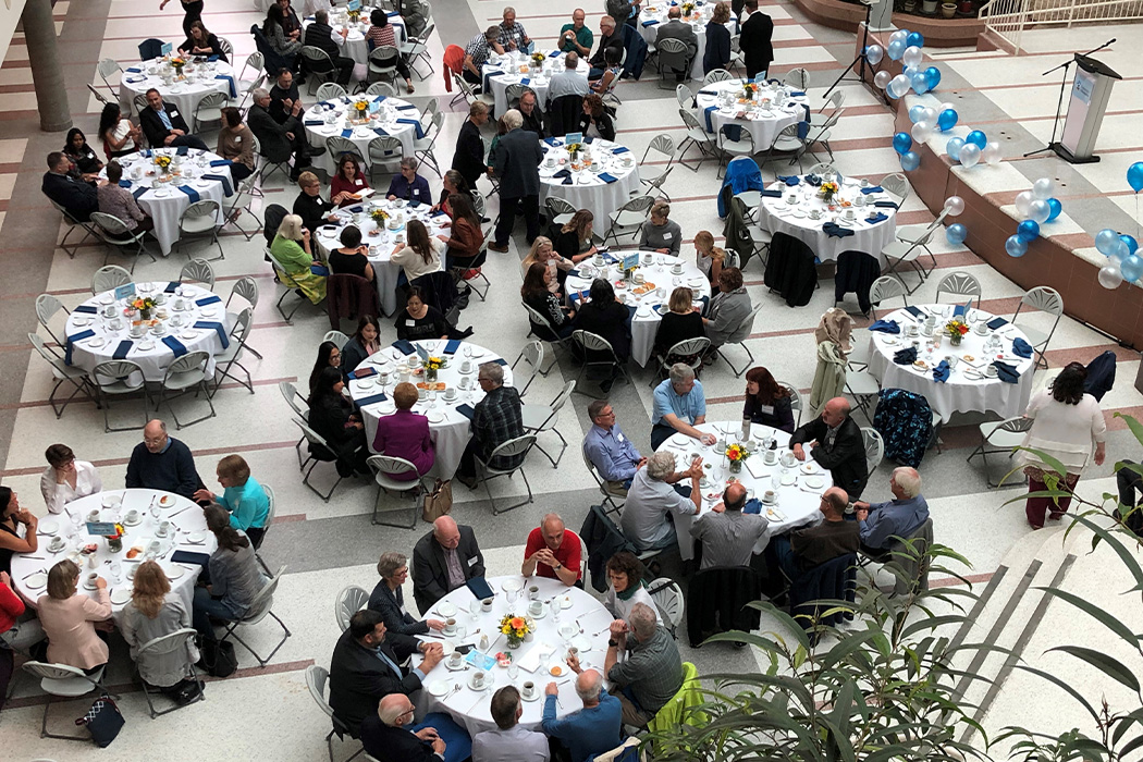 alumni sitting at tables in brodie atrium for dean's breakfast