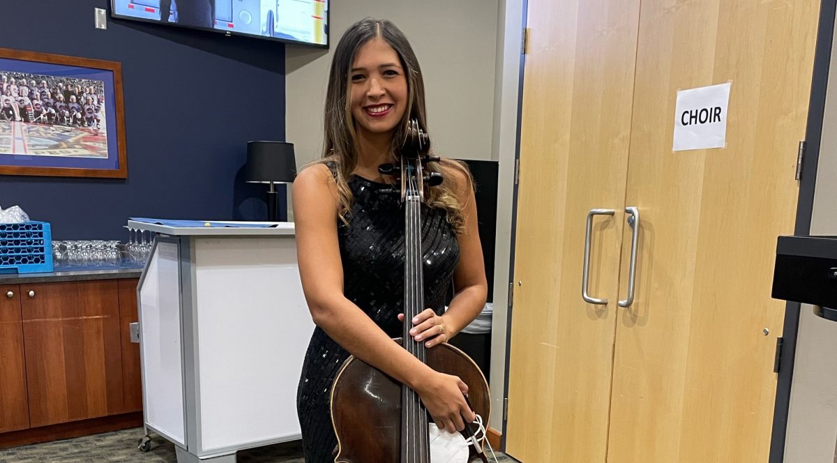 Law student Edvanny Silva Burns holding cello backstage at Michael Buble concert