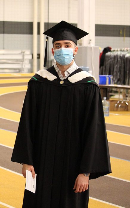 A male student in cap and gown.