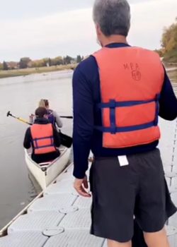 A still image from a video of Brian Rice and students launching a canoe.