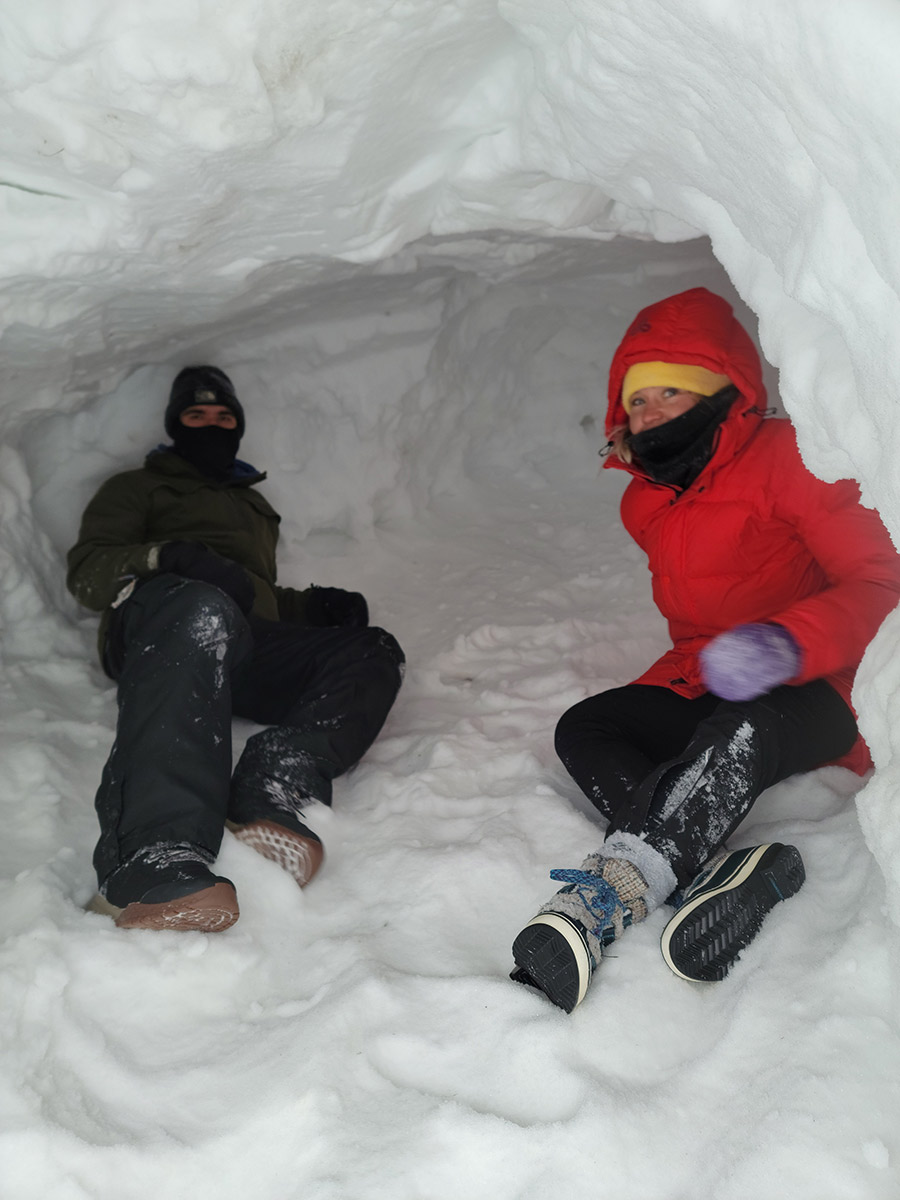 Students building a snow shelter in heavy parkas. // photo courtesy of Brian Rice.