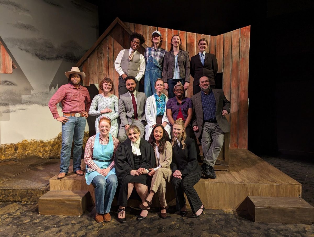 Group of actors in farming costumes on stage.