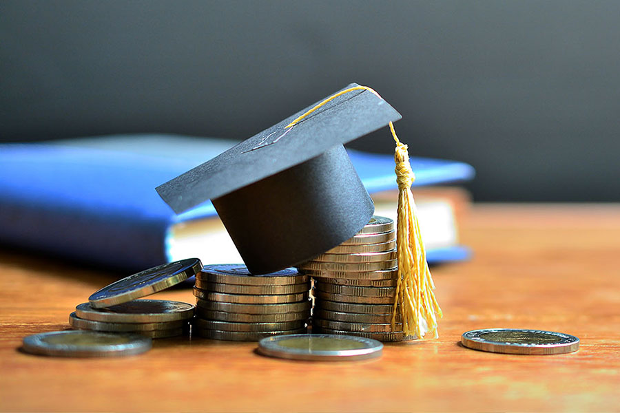 Photo of book, graduation cap, and toonies.