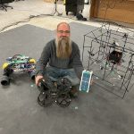 Dr. Philip Ferguson with some of his team's drones and spacecraft