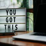 A lightbox sign on a desk reads "You got this"