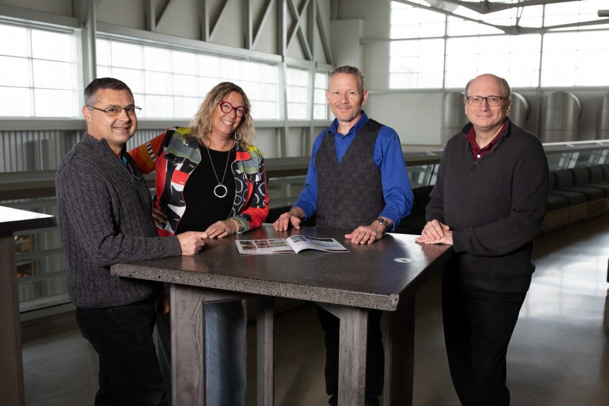 Four staff members standing around a table in the Engineering Building