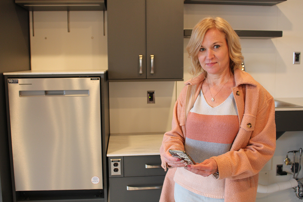 Jacquie Ripat in the smart suite kitchen with her smartphone.