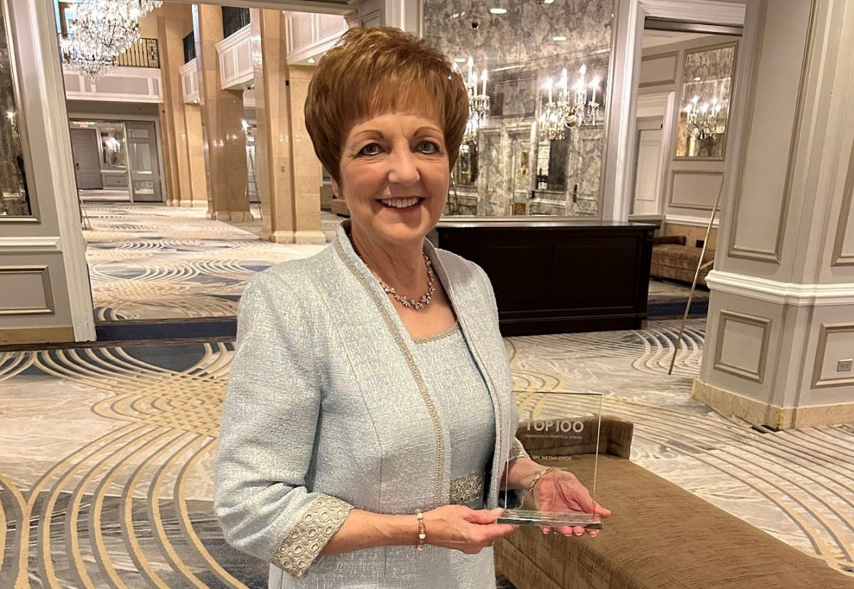 Dr. Netha Dyck holding an award and smiling