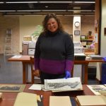 Head, Archives & Special Collections Heather Bidzinski alongside pieces from the archives.