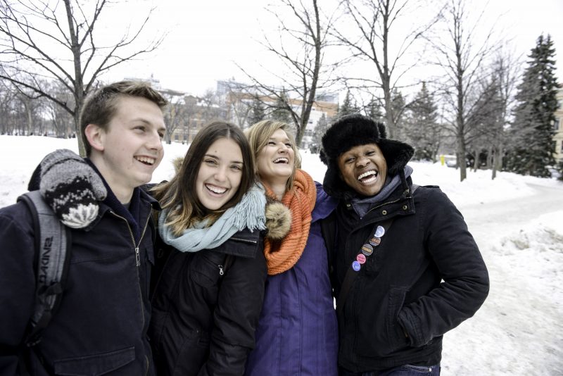 Smiling group of four students outdoors in winter.