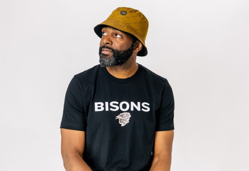Ogo Okwumabua sitting with a hat on and a Bison T-shirt