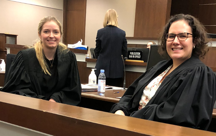 Sarah Sharp (3L) (left) and Aiyana McKenzie (3L) (right) take a moment mid-moot at the 2023 MacIntyre Cup trial advocacy moot held in Calgary. Photo by Chantal Boutin.