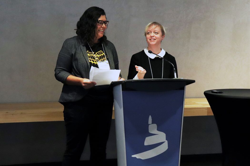 Dr. Marcia Anderson and Dr. Jillian Waruk stand at the podium at the Canadian Museum for Human Rights.
