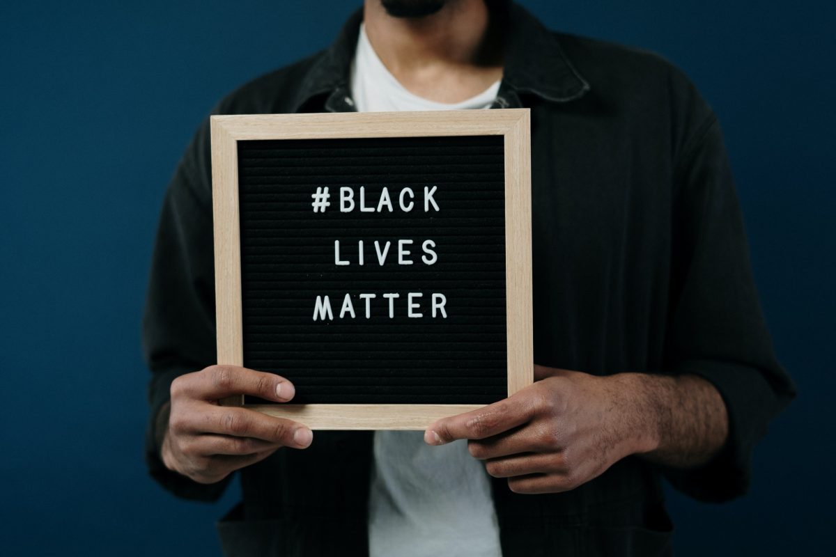 Close up of a letter-board sign with letters spelling ‘Black Lives Matter’ held by a Black man.