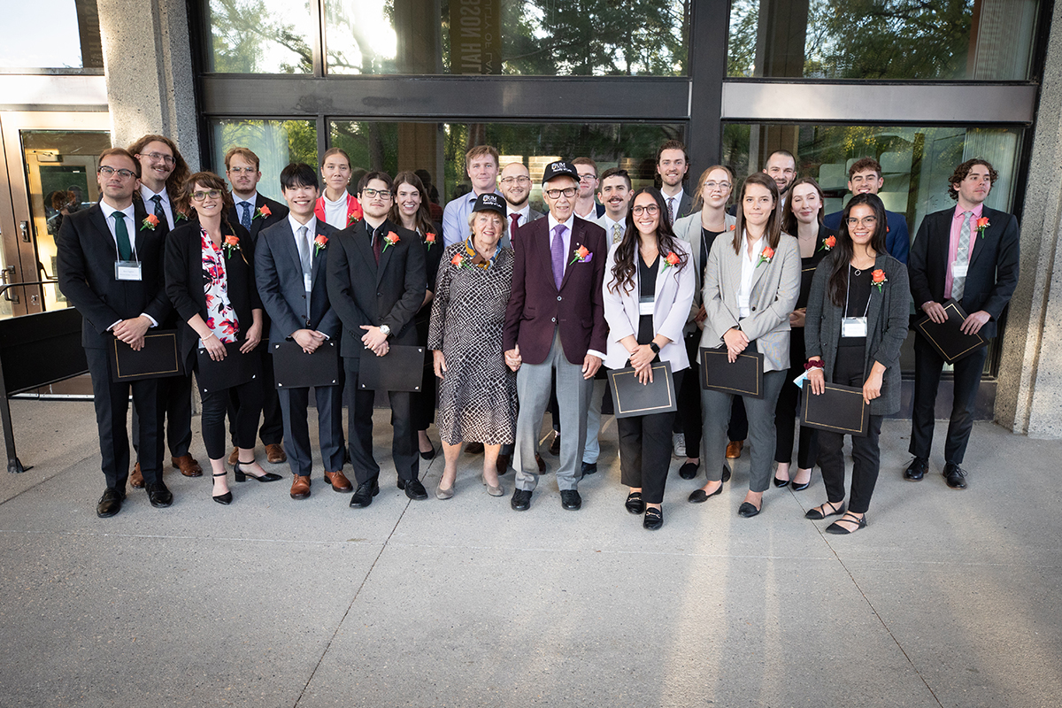 A group of students gather around donors and smile at camera.