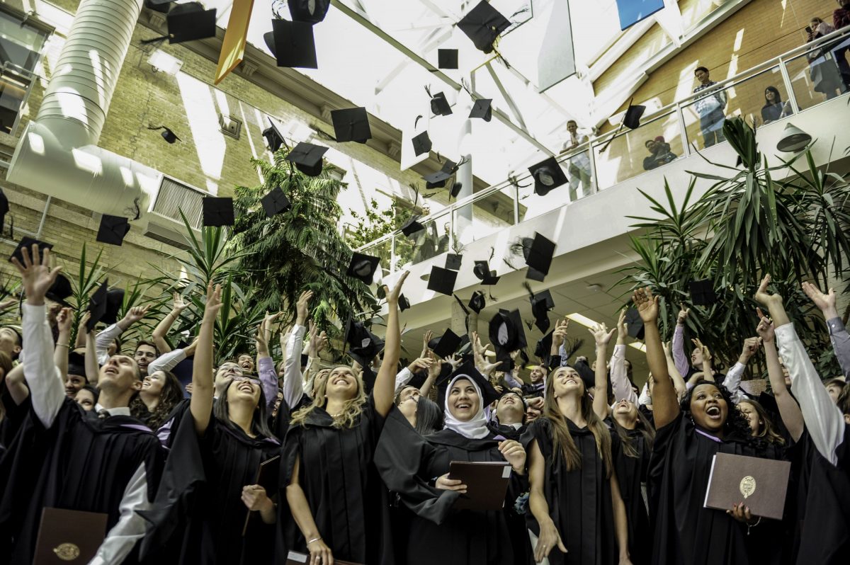 New grads throw their caps into the air in celebration.