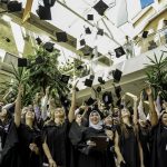 New grads throw their caps into the air in celebration.