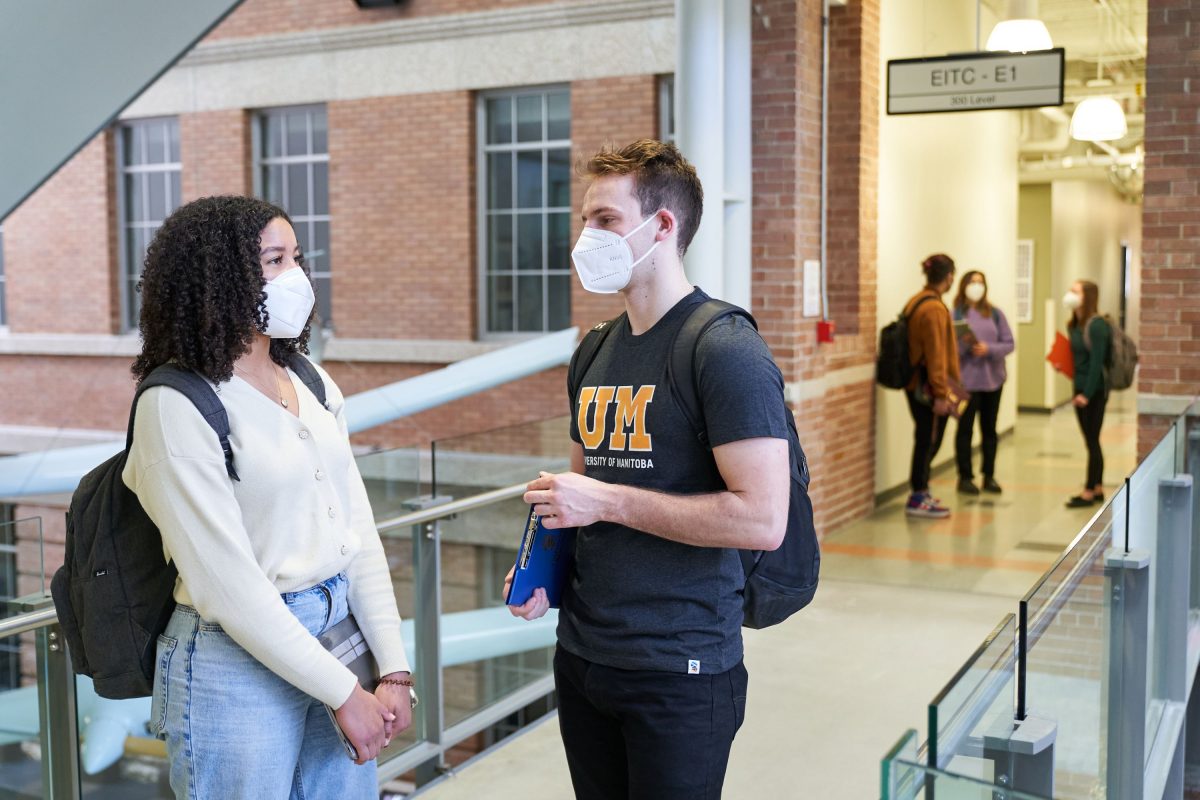 Students in masks chatting in a hallway