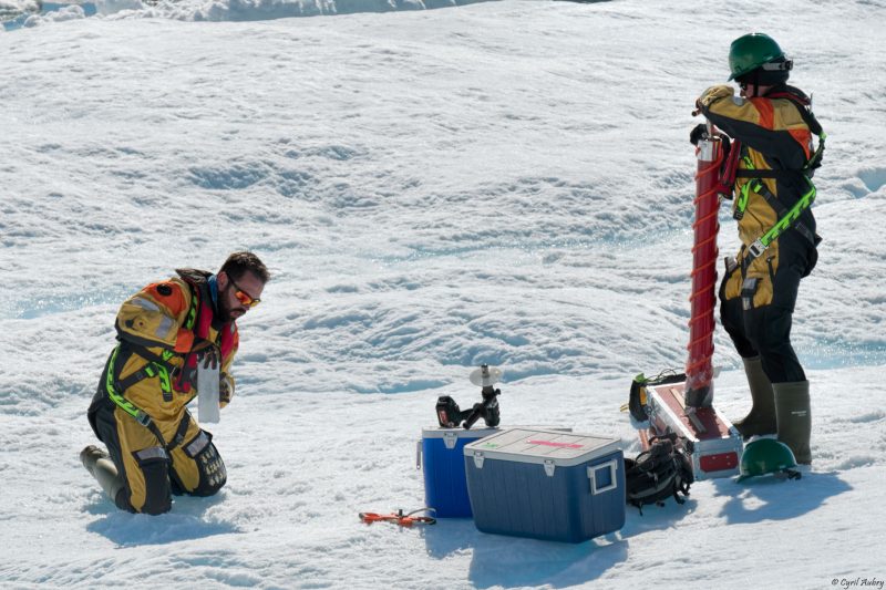 Scientists taking samples in the snow and ice.
