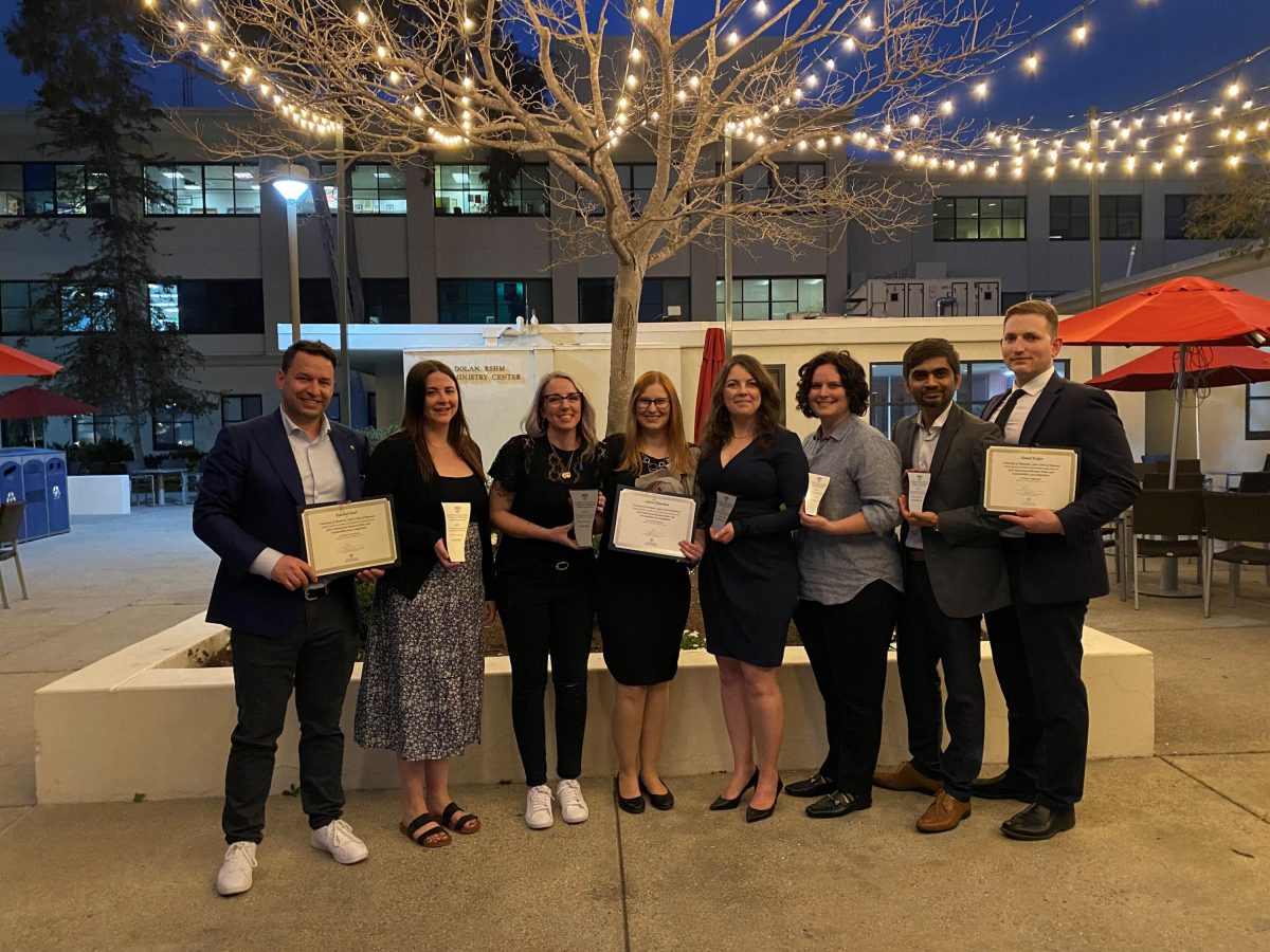 Eight individuals standing with certificates.