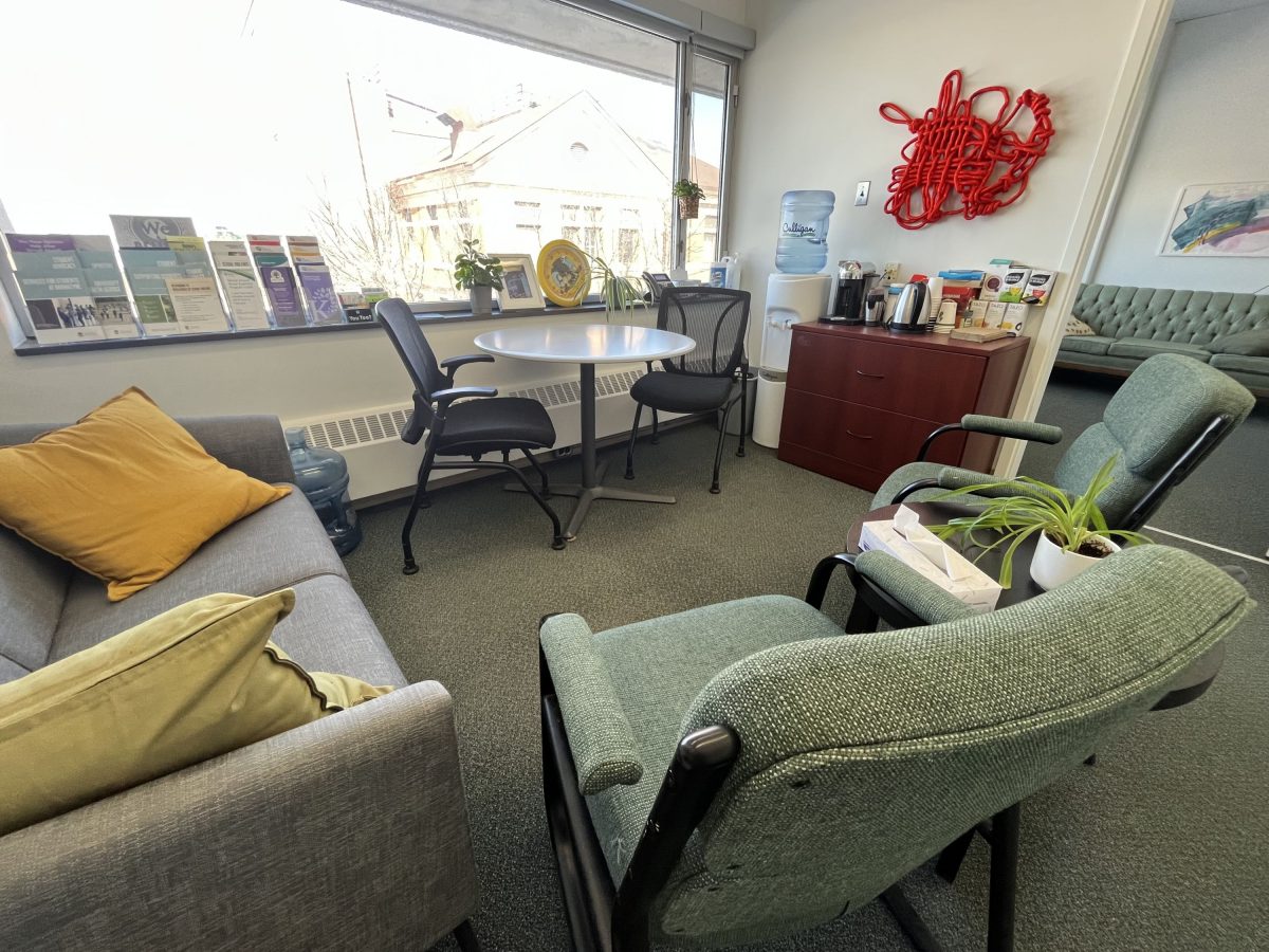 The SVRC's office welcome space is full of comfy chairs and colourful pillows, helpful pamphlets. A selection of teas are lined up beside a kettle. There is red rope art displayed on the wall. It is comfortable and inviting.