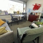 The SVRC's office welcome space is full of comfy chairs and colourful pillows, helpful pamphlets. A selection of teas are lined up beside a kettle. There is red rope art displayed on the wall. It is comfortable and inviting.