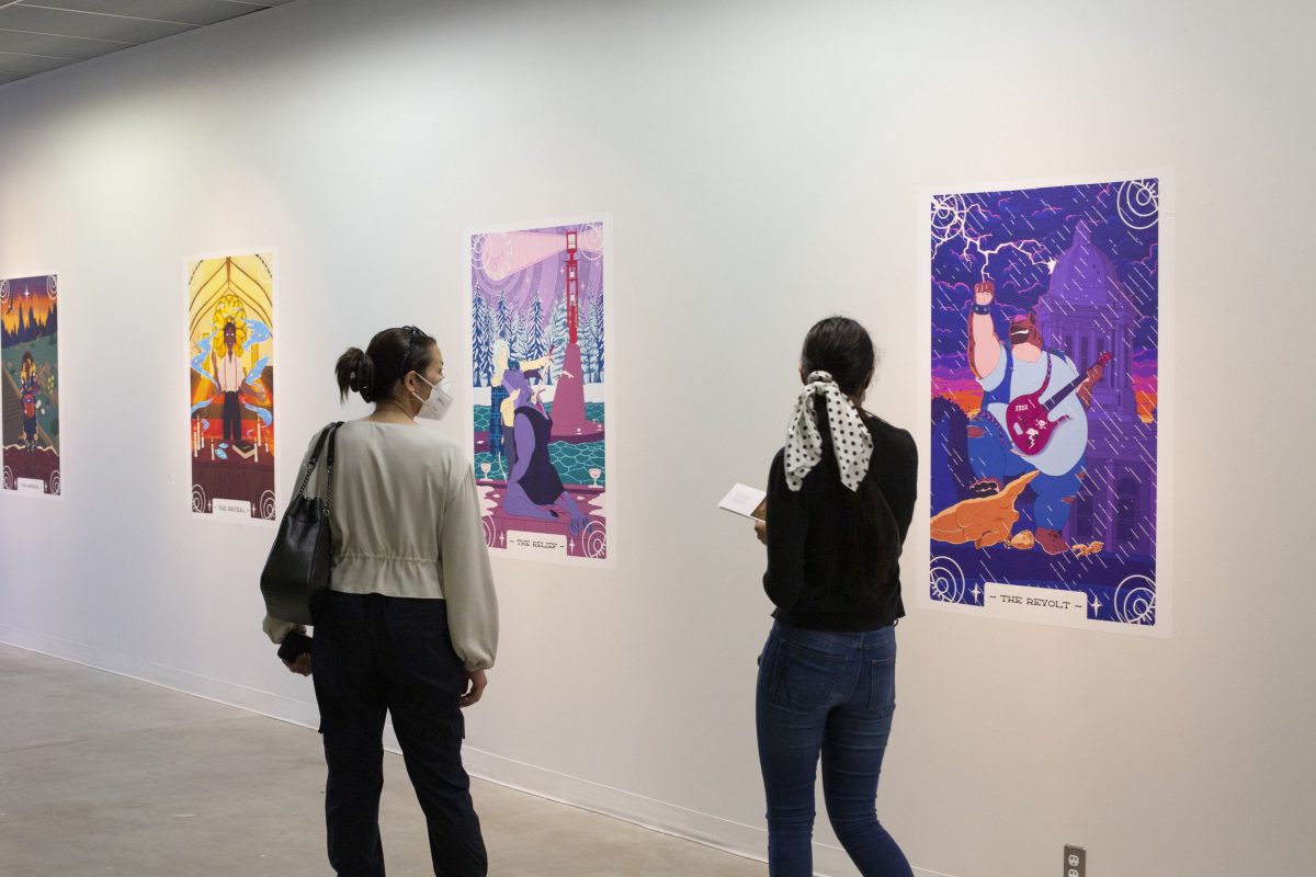People walking past and viewing colourful artwork in an exhibition space.