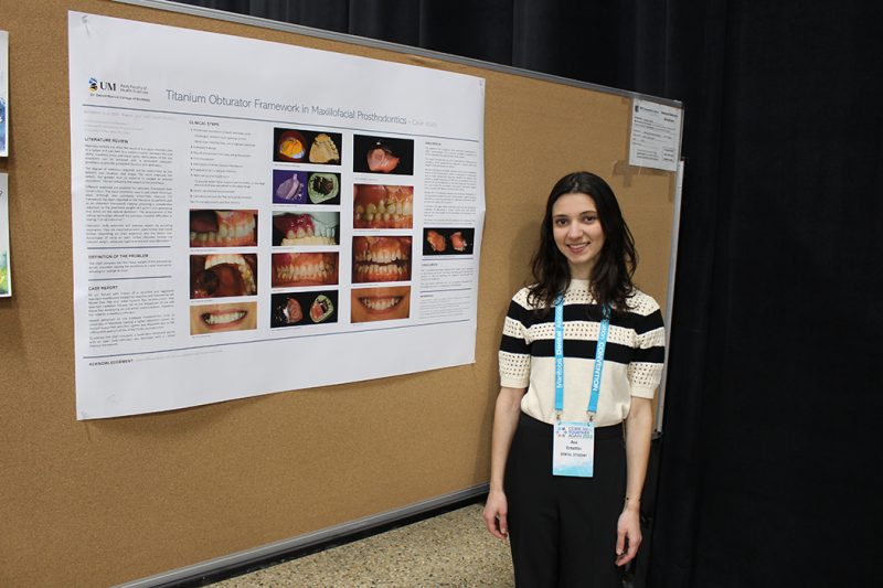Dr. Ana Schettini stands next to her research poster at a Research Day event.