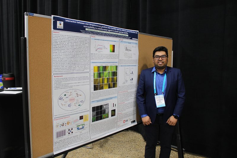 Md Mahamudul Haque stands near his research poster at Research Day event. 