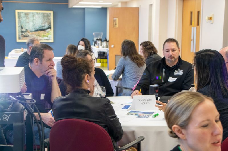 Attendees at the Experiential Learning Gathering sitting around a table. 