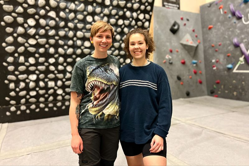 Climbers posing for picture in front of the Kilter Board