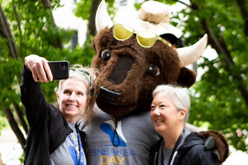 Group of people at sneaker day event taking selfie with Billy the Bison