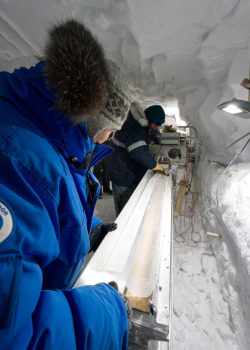 People looking at ice core in snow tunnel.