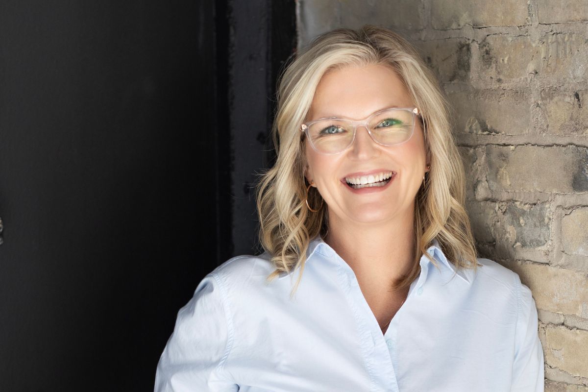 blond white woman with glasses smiling