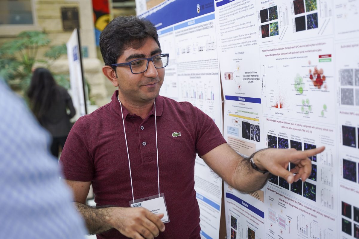 Seyed Mojtaba Hosseini pointing to his research poster