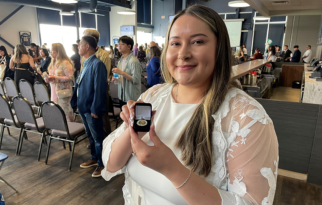 Winter Traverse poses with her College of Nursing pin inside the Pinnacle Club.