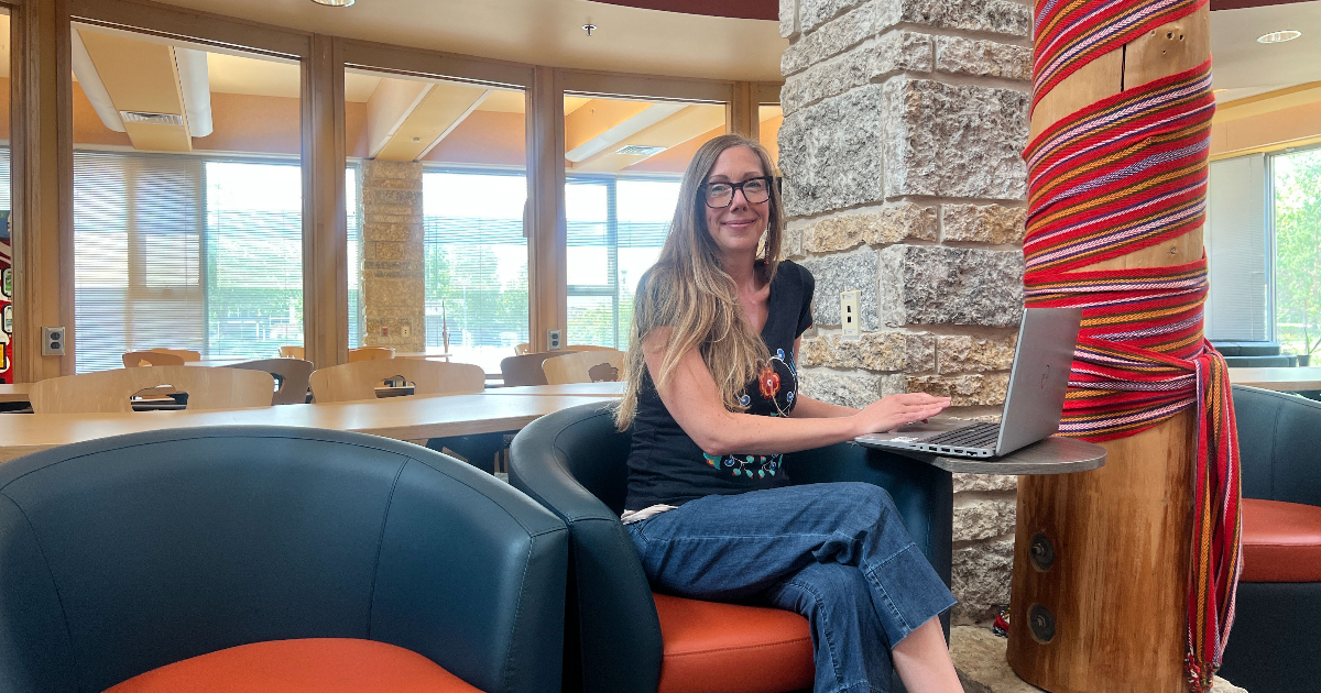 Max Rady College of Medicine's admissions administrator Elizabeth Spence, sitting on a chair in the Migizii Agamik lounge.