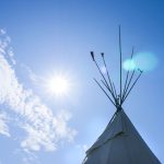 tip of a teepee shown against a bluesky