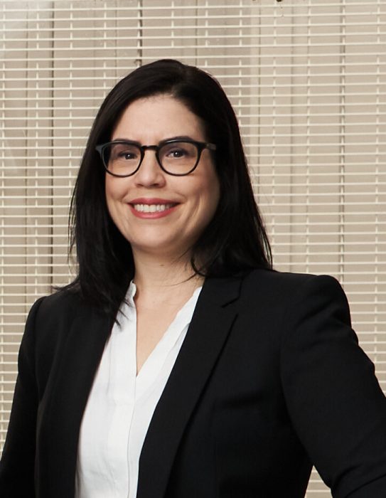 headshot of woman with dark hair and glasses