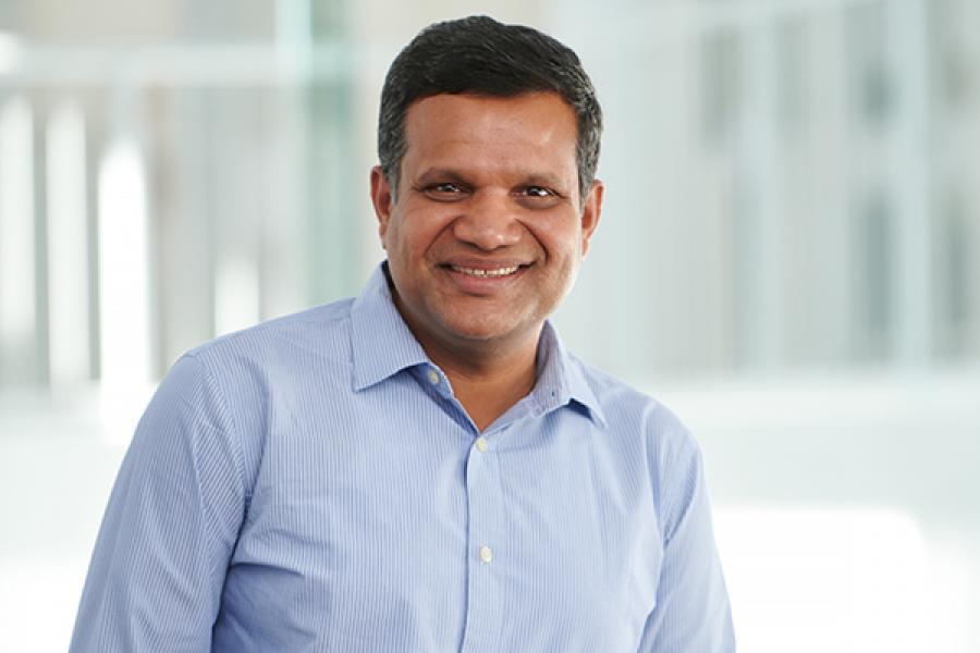 Man in blue shirt smiling.