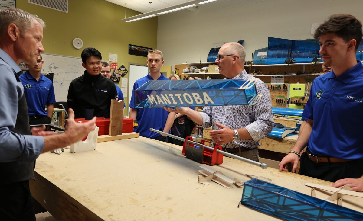 people in workshop looking at airplane parts