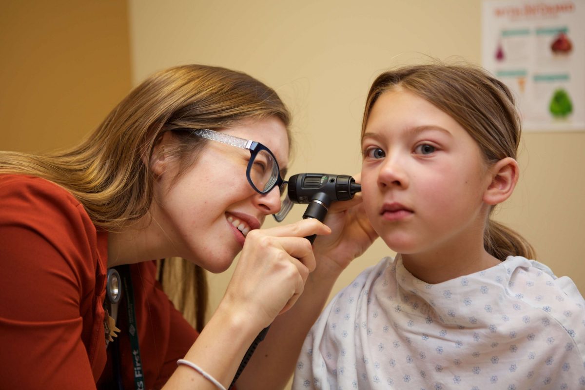Physician examines a child's ear.