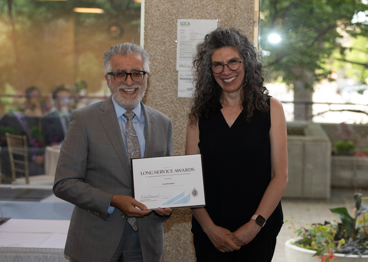 Honouree and linguistics professor Jila Ghomeshi accepts her Long Service Award from President Benarroch.