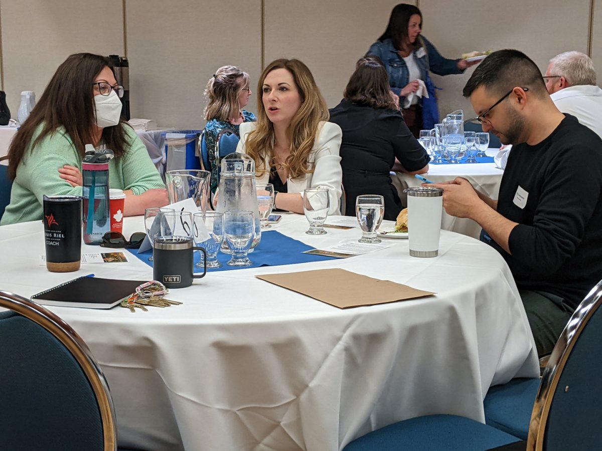 Three Teaching Café attendees having a discussion.