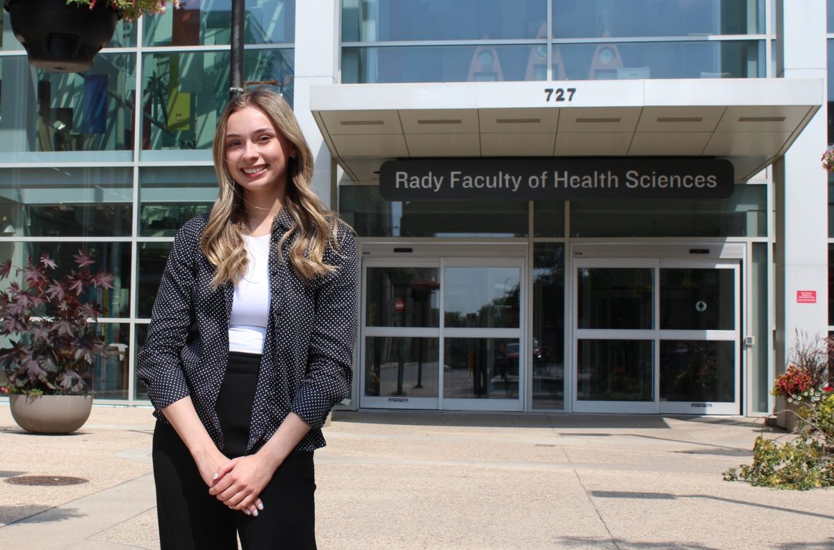 Student Alexa Pommer standing outside the Rady Faculty of Health Sciences Brodie Atrium.